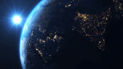 Earth at sunrise with city lights visible
