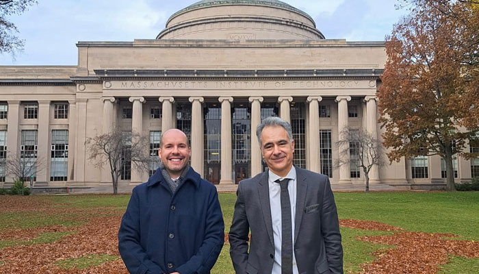 Alexandre and João in front of MIT dome in autumn.